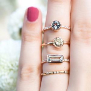 assortment of trendy gemstone rings on hand